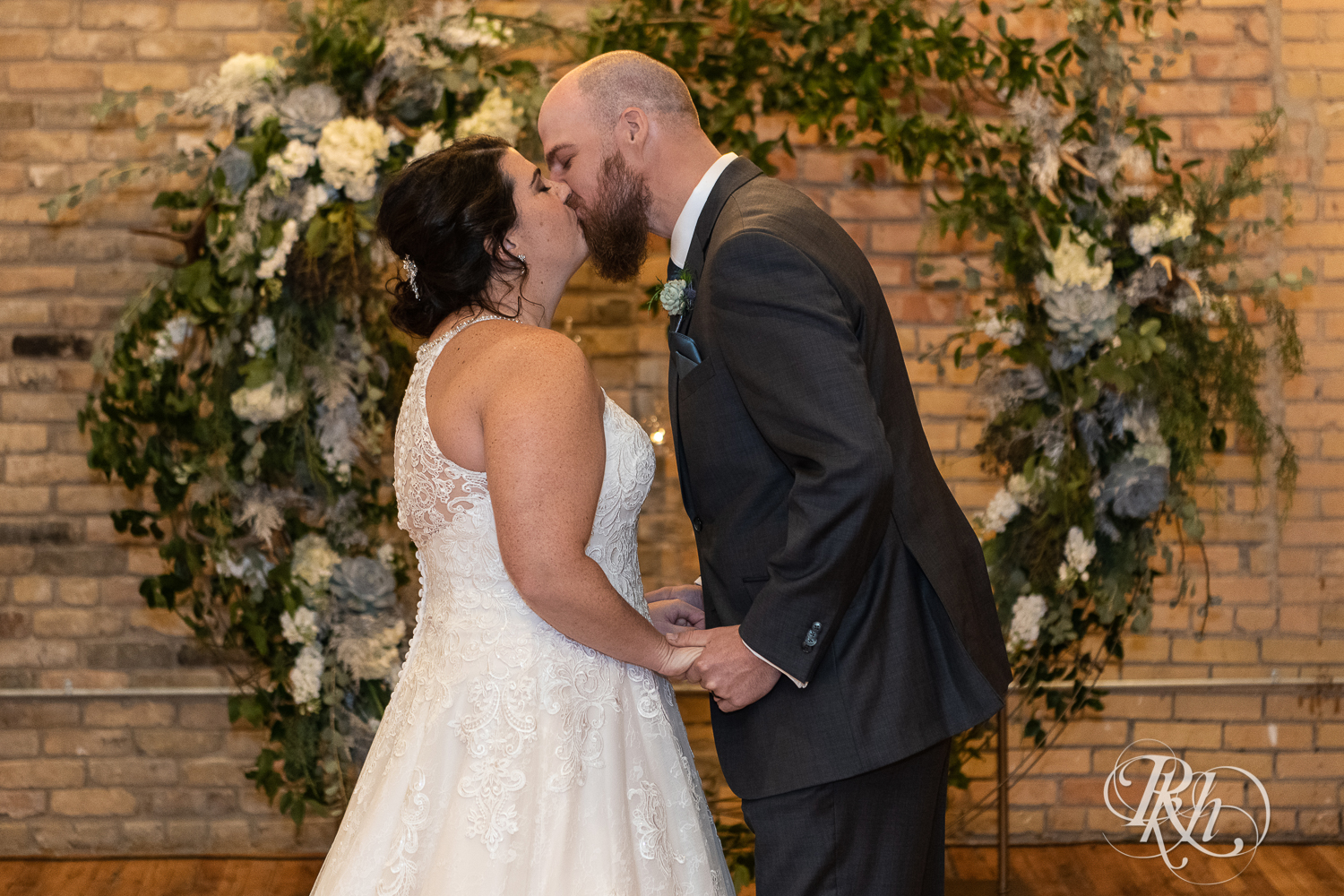 Bride and groom kiss during wedding ceremony at Minneapolis Event Centers in Minneapolis, Minnesota.