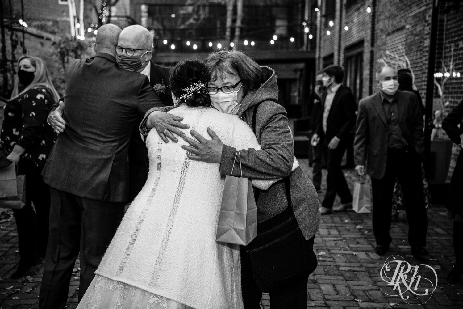 november wedding bride and groom hugging people