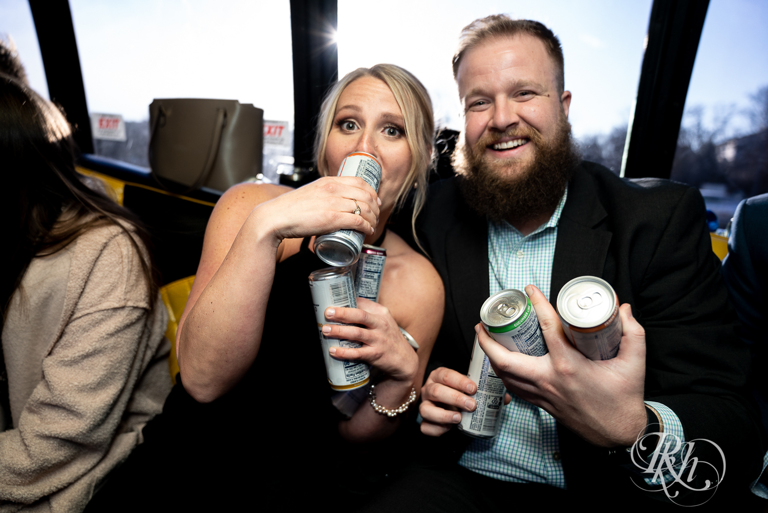 Bride and groom drink with wedding party on party bus after wedding ceremony in Faribault, Minnesota.