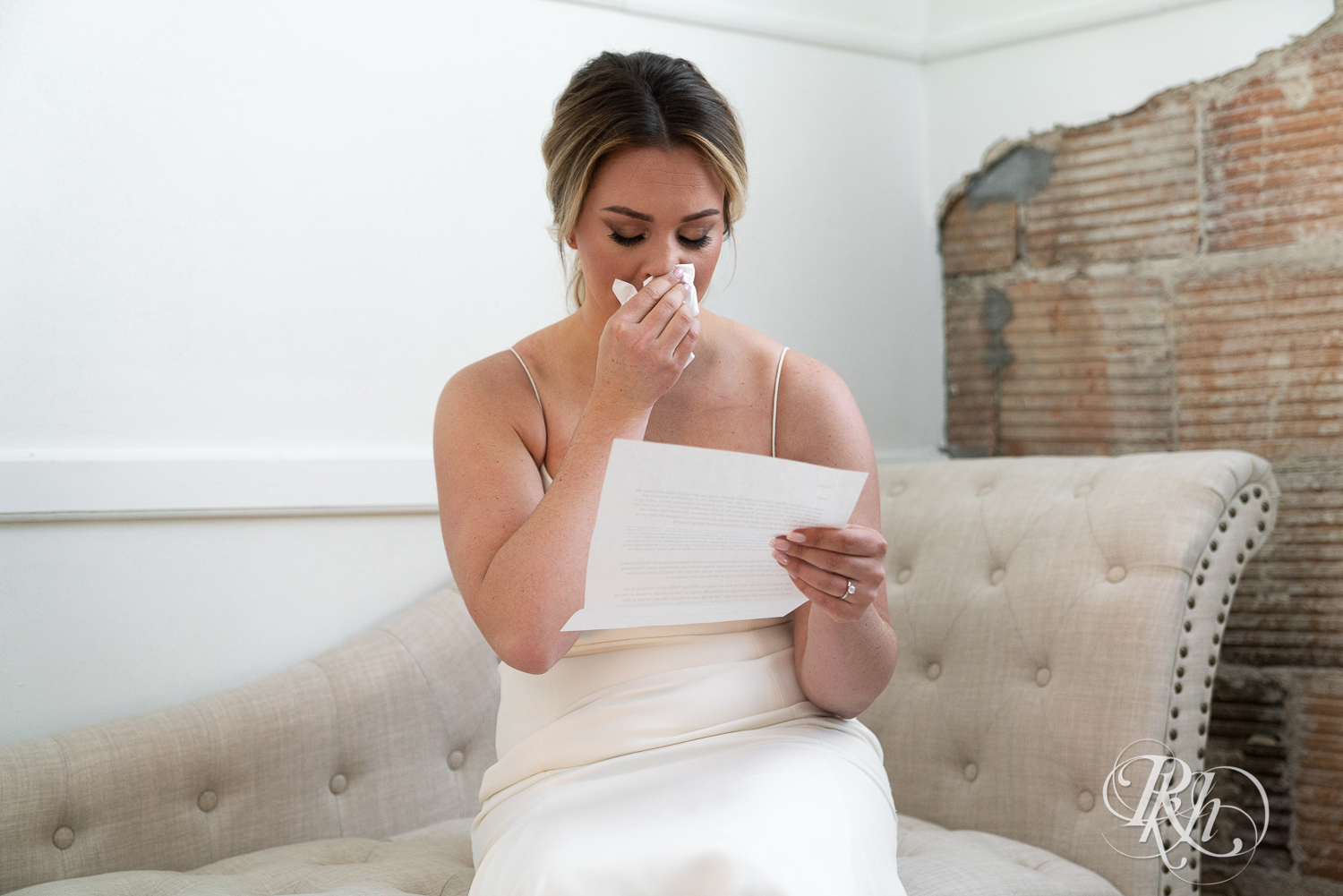 Bride reading letter from groom on wedding day at the 3 Ten Event Center in Faribault, Minnesota.