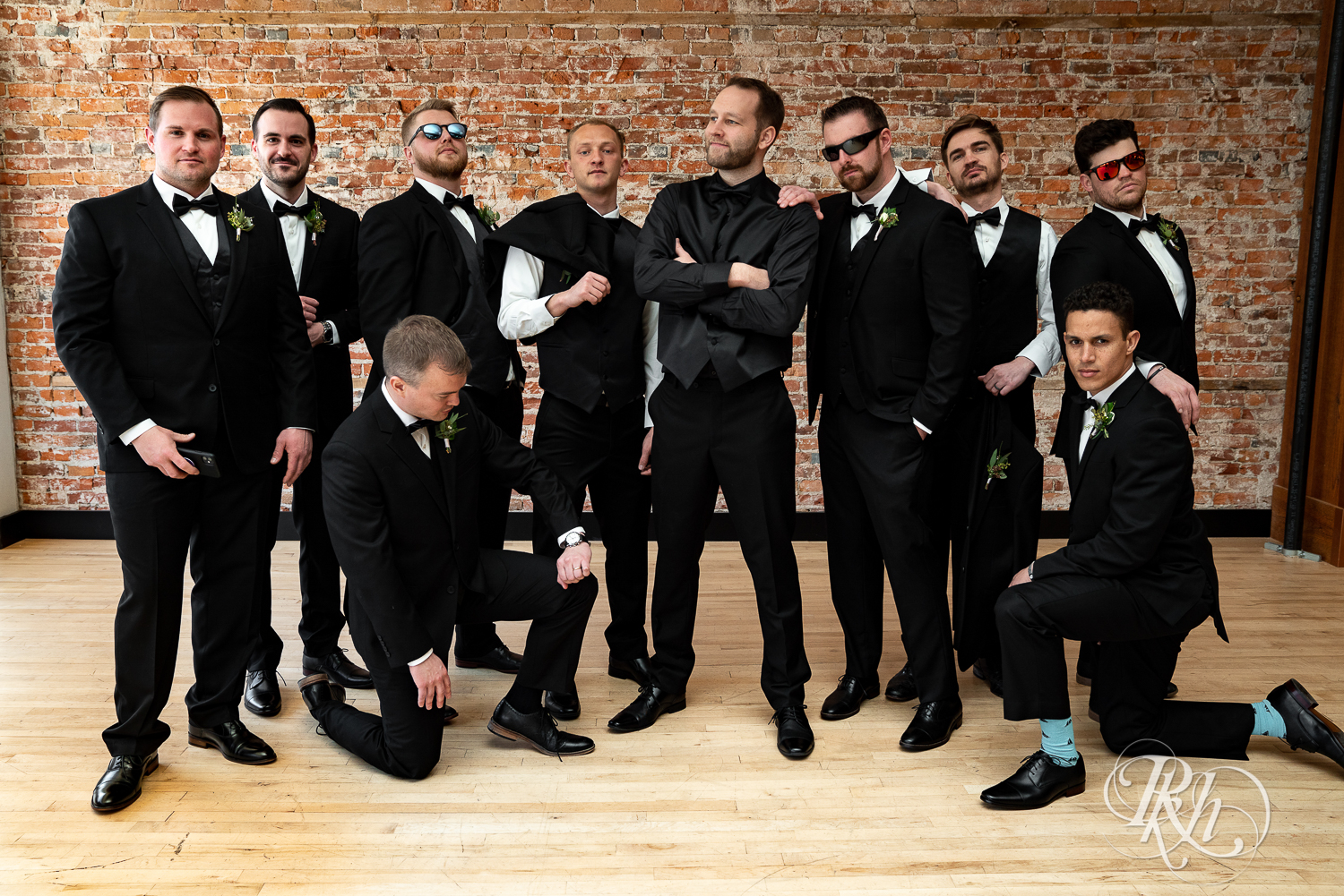 Wedding party in black suits smile at the 3 Ten Event Center in Faribault, Minnesota.