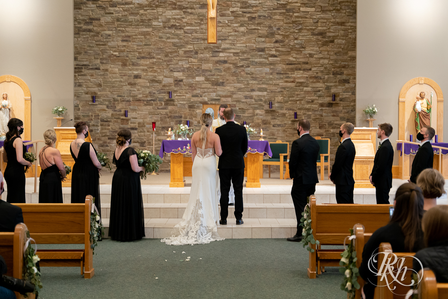 Bride and groom stand in front of pastor in church wedding ceremony in Faribault, Minnesota.