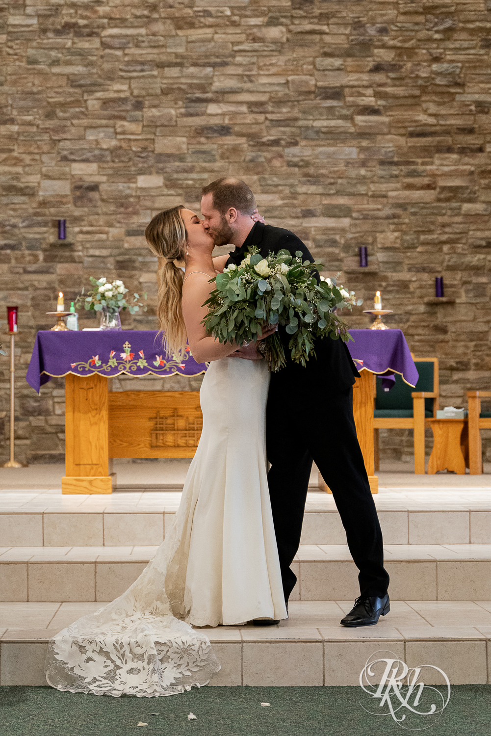 Bride and groom kiss in church wedding ceremony in Faribault, Minnesota.