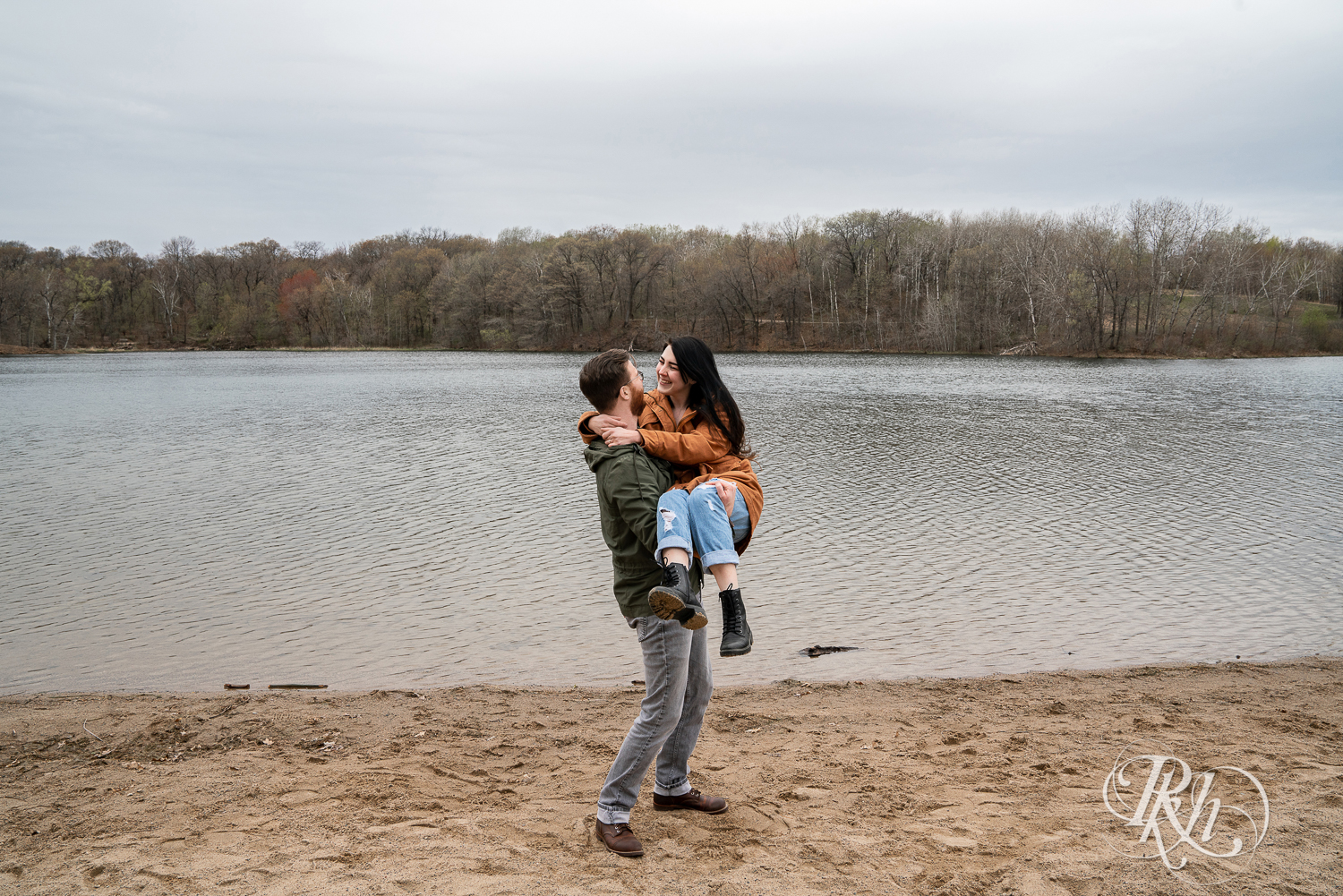 Man carries woman on beach at Lebanon Hills Regional Park in Eagan, Minnesota. 
