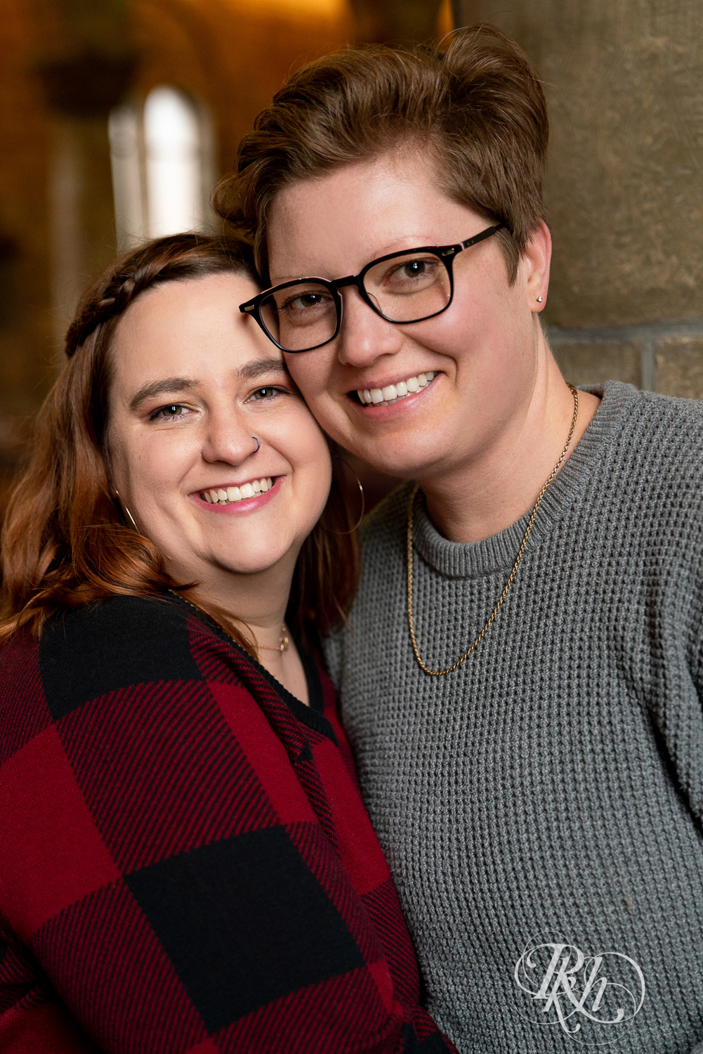 Lesbian couple smile and hold hands in Saint Catherine's in Saint Paul, Minnesota. 