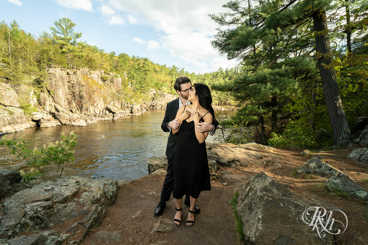 Man in suit and woman in long black dress dance on cliff at Interstate State Park in Taylor's Fall, Minnesota.
