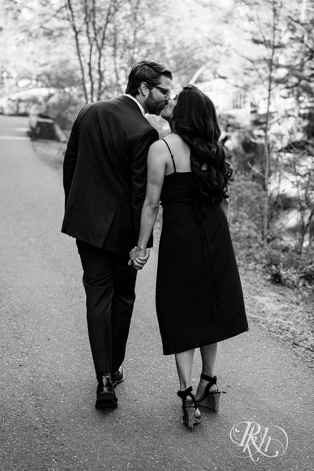 Man in suit and woman in long black dress kiss at Interstate State Park in Taylor's Fall, Minnesota.
