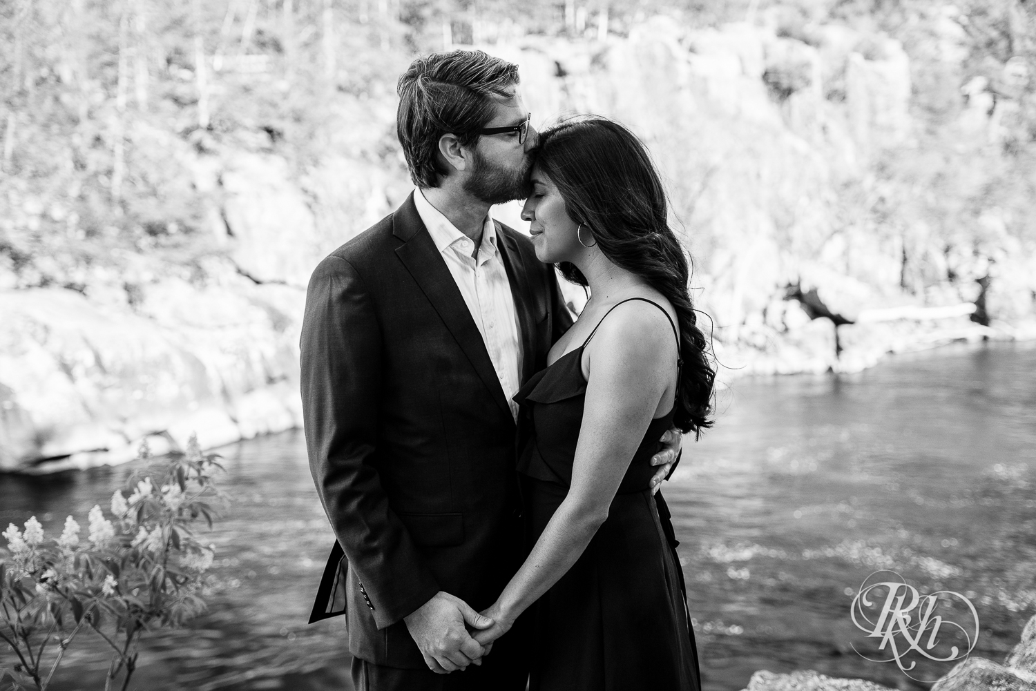 Man in suit and woman in long black dress kiss at Interstate State Park in Taylor's Fall, Minnesota.