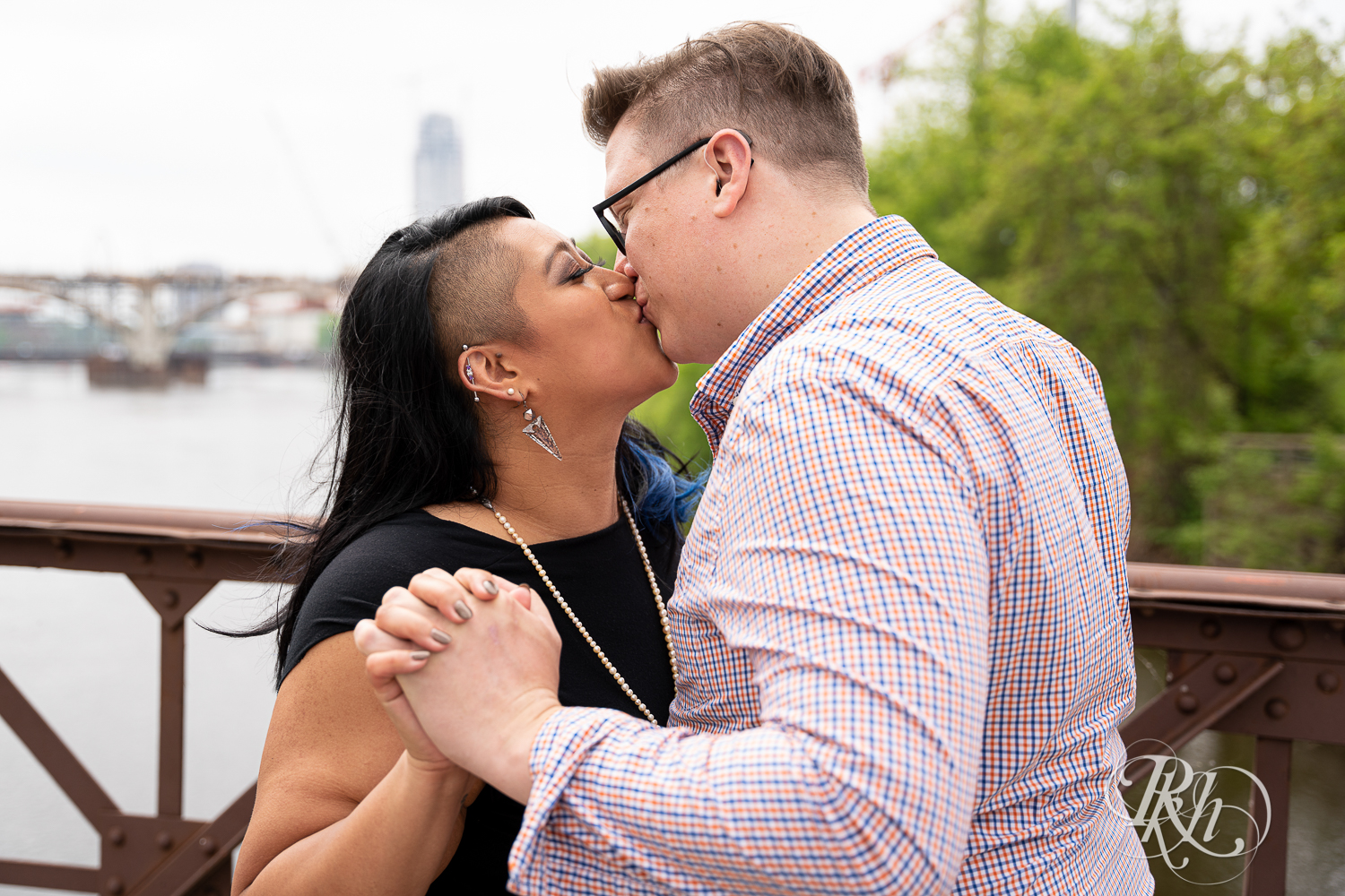 Man and Filipino woman kiss on Nicollet Island in Minneapolis, Minnesota.