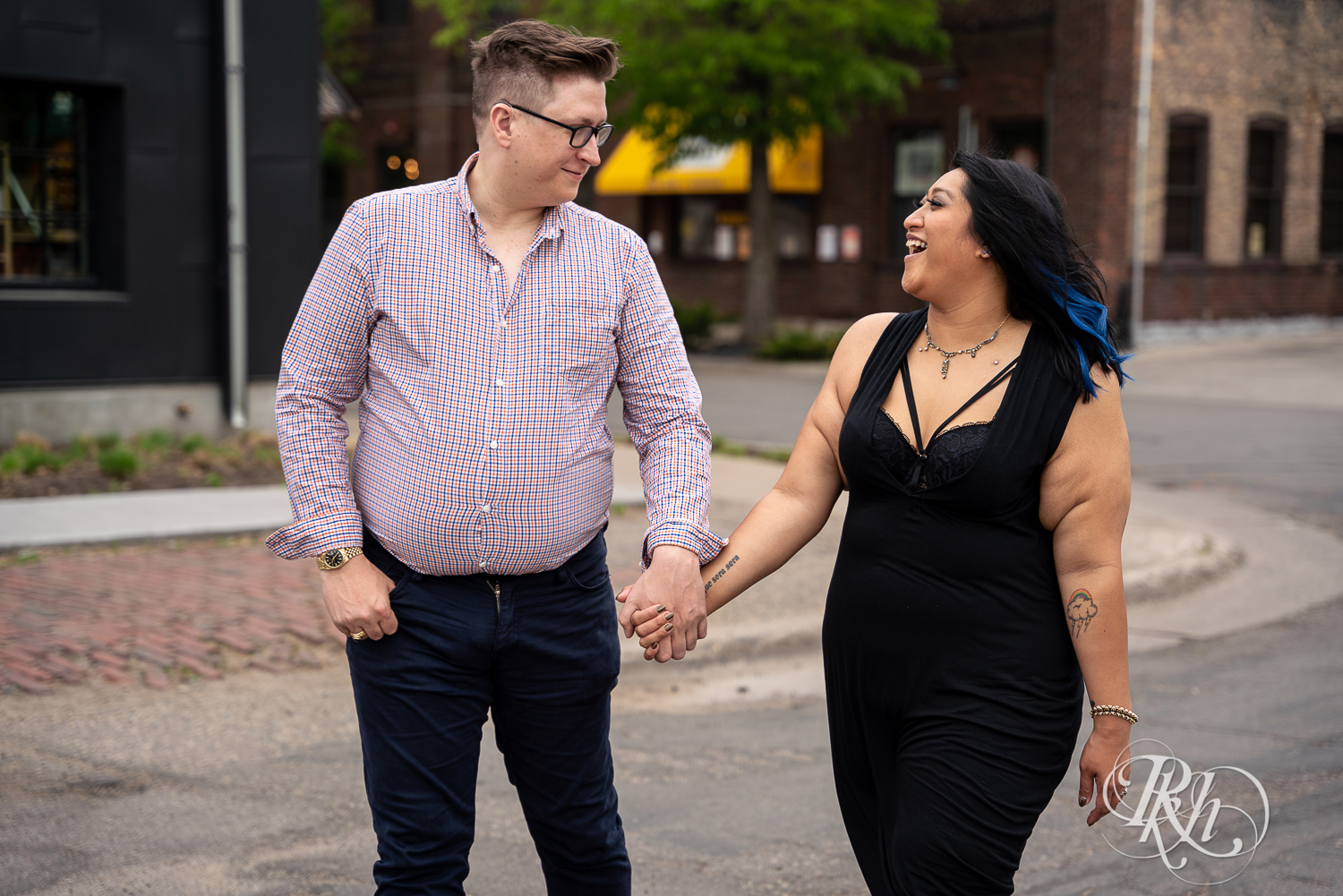 Man and Filipino woman walk down street laughing in Minneapolis, Minnesota.