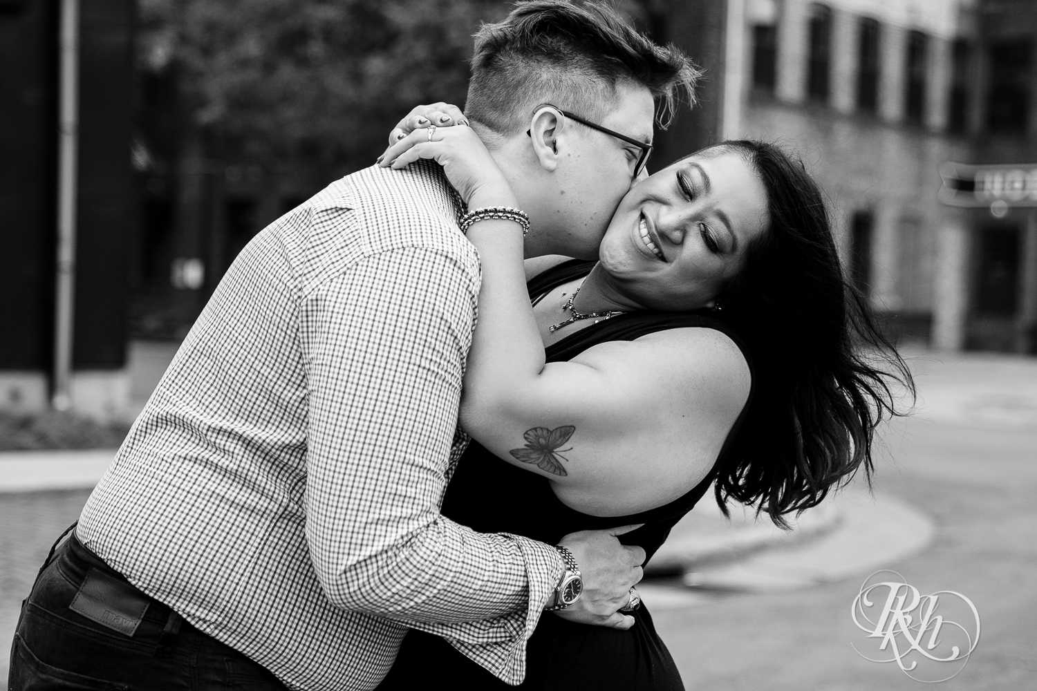 Man and Filipino woman kiss in street laughing in Minneapolis, Minnesota.