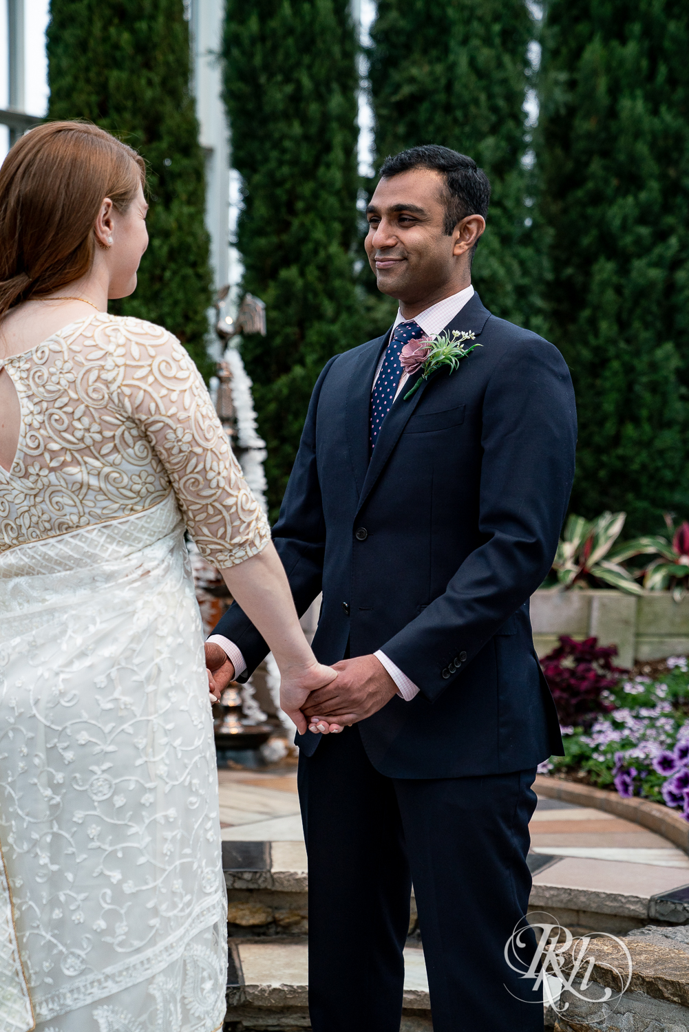 Bride and groom smiling during ceremony at Indian wedding at Como Zoo Conservatory in Saint Paul, Minnesota.