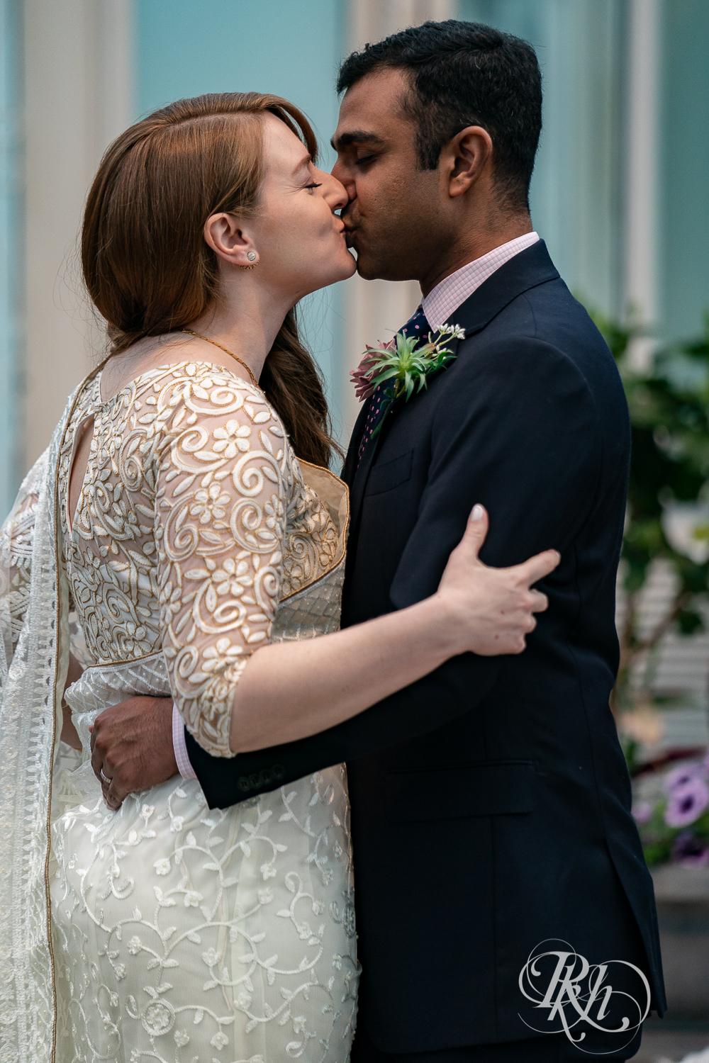 Bride and groom kiss during ceremony at Indian wedding at Como Zoo Conservatory in Saint Paul, Minnesota.