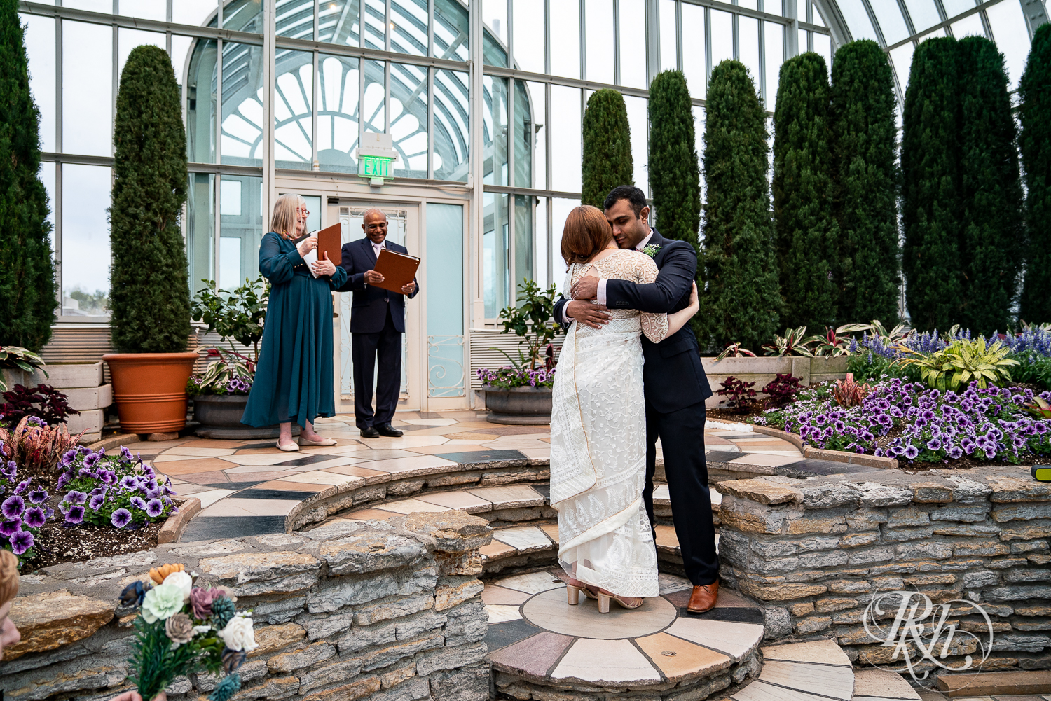 Bride and groom hug during ceremony at Indian wedding at Como Zoo Conservatory in Saint Paul, Minnesota.