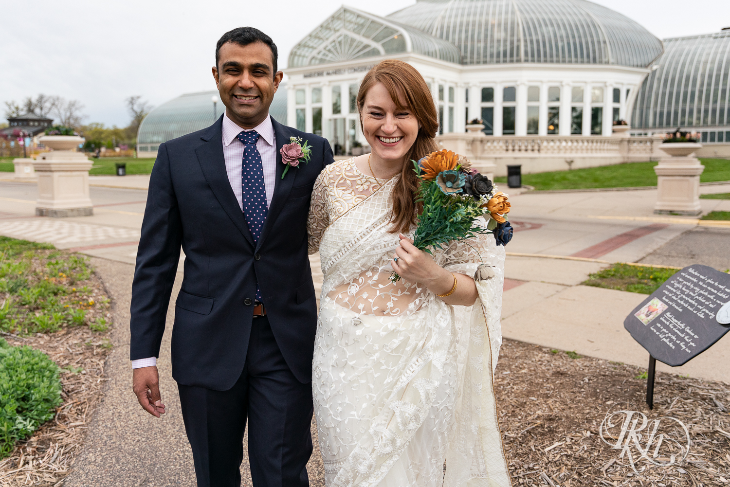 Bride and groom laugh outside at Indian wedding at Como Zoo Conservatory in Saint Paul, Minnesota.