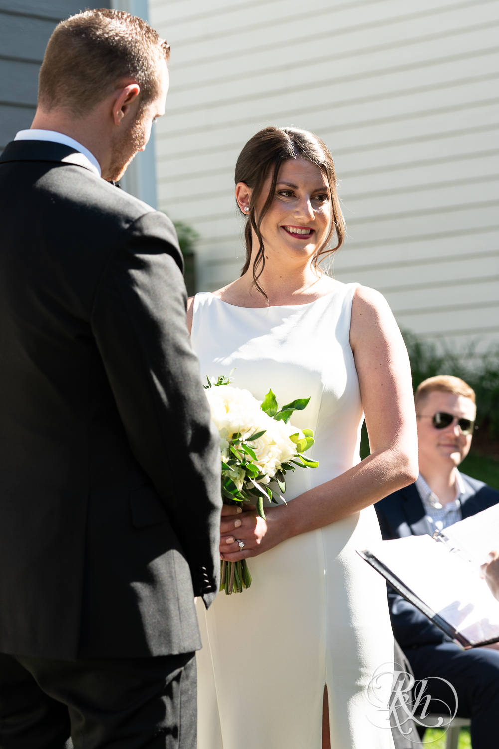 Bride and groom smiling at wedding ceremony at home in Eagan, Minnesota.