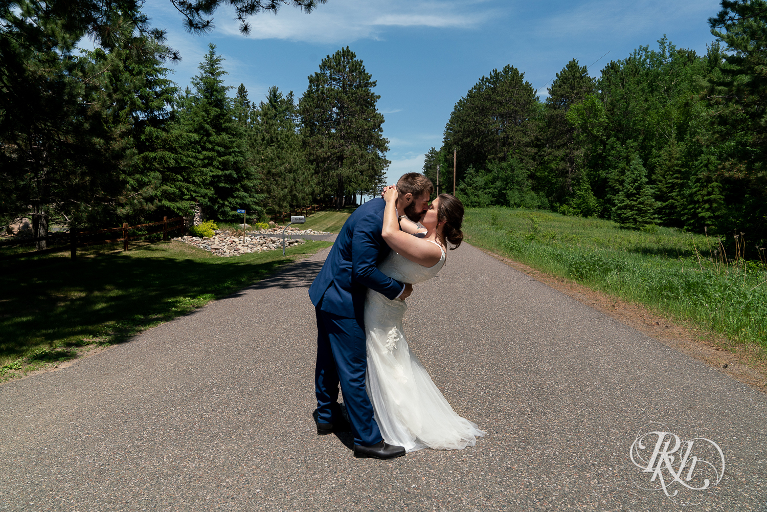 Bride and groom kiss in road at Pine Peaks Event Center in Pine River, Minnesota.