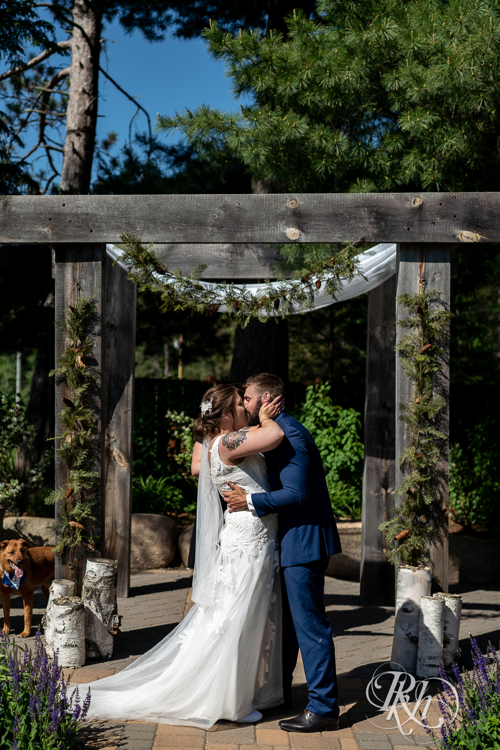 Bride and groom kiss at wedding ceremony at Pine Peaks Event Center in Pine River, Minnesota.
