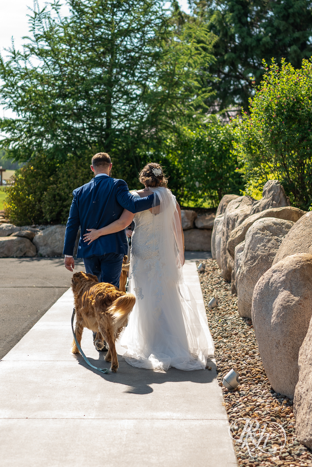 Bride and groom walk dogs at wedding ceremony at Pine Peaks Event Center in Pine River, Minnesota.