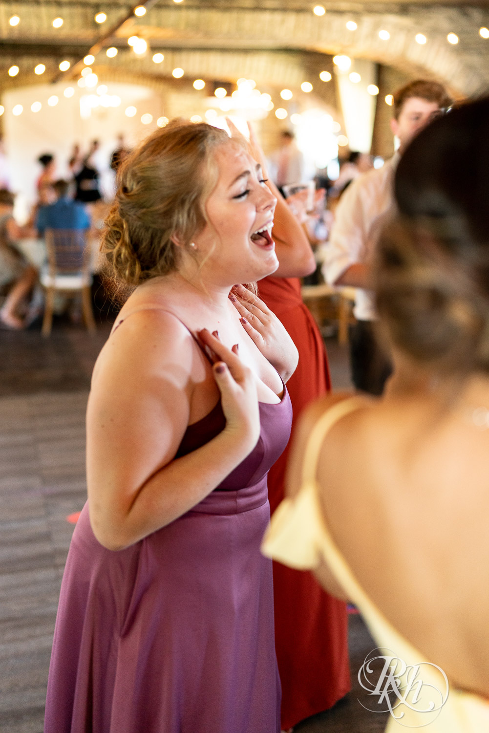 Guests dance with bride and groom at wedding reception at Mayowood Stone Barn in Rochester, Minnesota.
