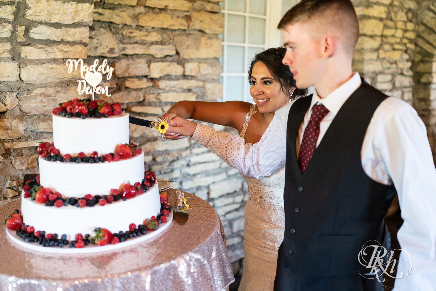 Bride and groom cutting cake at wedding reception at Mayowood Stone Barn in Rochester, Minnesota.