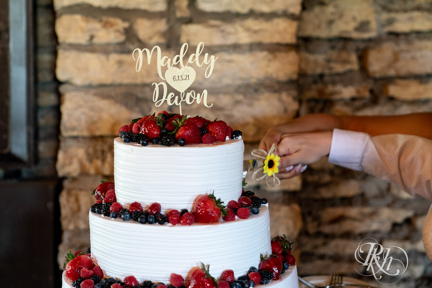 Bride and groom cutting cake at wedding reception at Mayowood Stone Barn in Rochester, Minnesota.