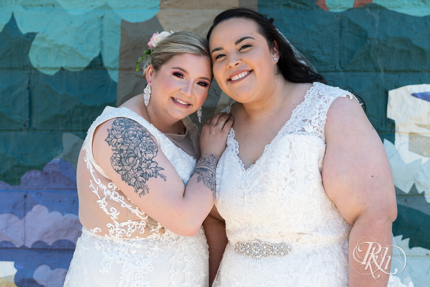 Lesbian brides smile during wedding day at Cannon River Winery in Cannon Falls, Minnesota.