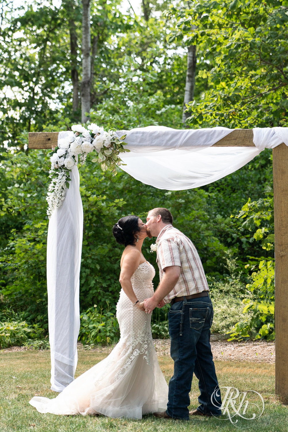 Bride and groom kiss at wedding ceremony at Croix View Farm in Osceola, Wisconsin.