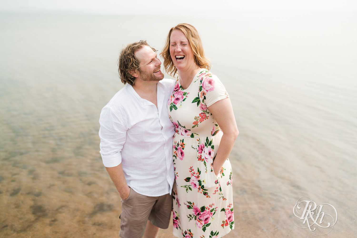 Man and woman laugh in Lake Superior on Park Point Beach in Duluth, Minnesota.