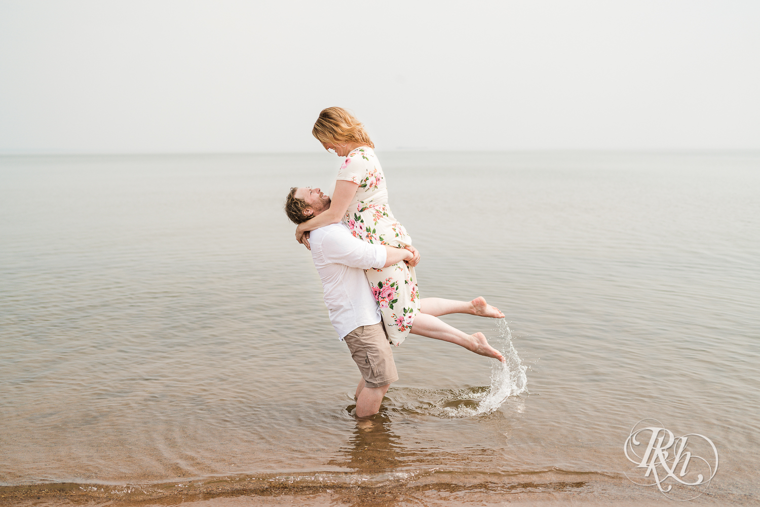 Man lifts woman in Lake Superior on Park Point Beach in Duluth, Minnesota.