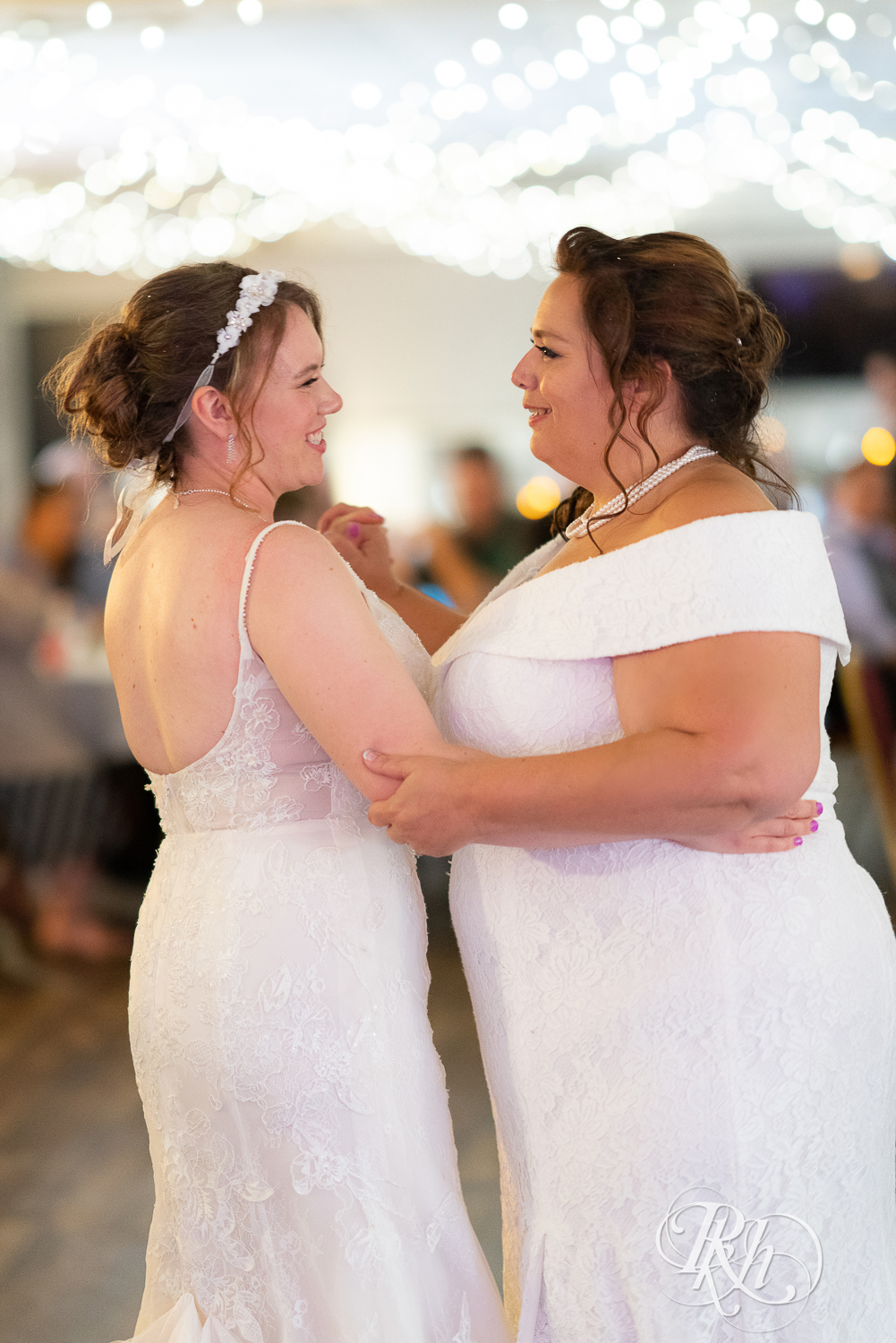 Lesbian brides share first dance at wedding reception at Willy McCoy's in Champlin, Minnesota.
