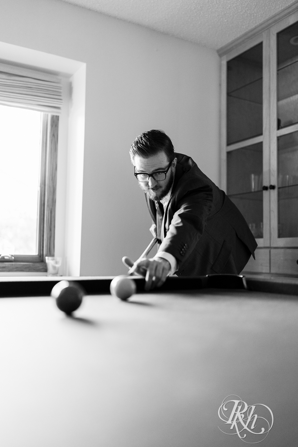 Groom plays pool at his house before his wedding.