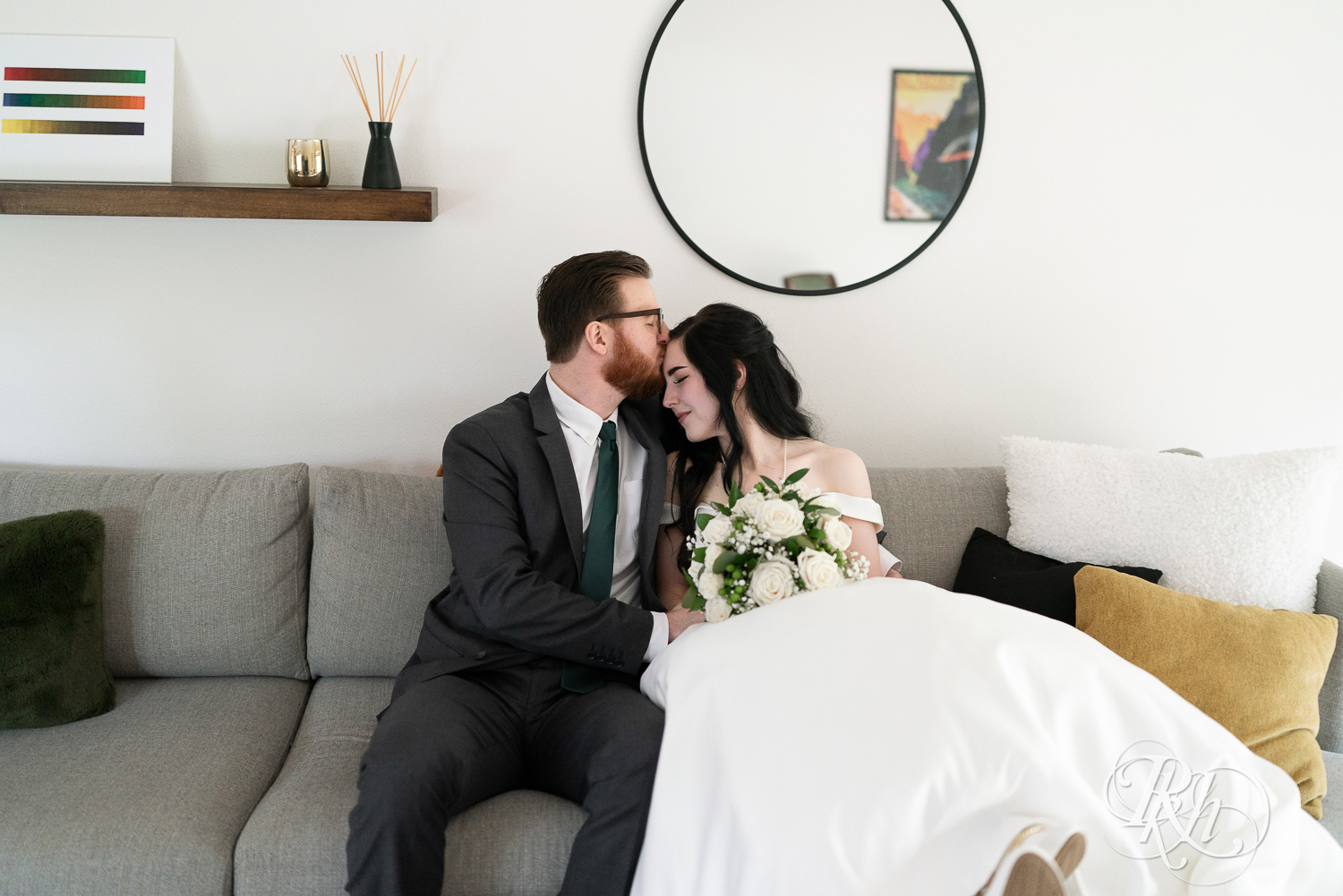 Bride and groom kiss on couch at their house wedding in Sartell, Minnesota.