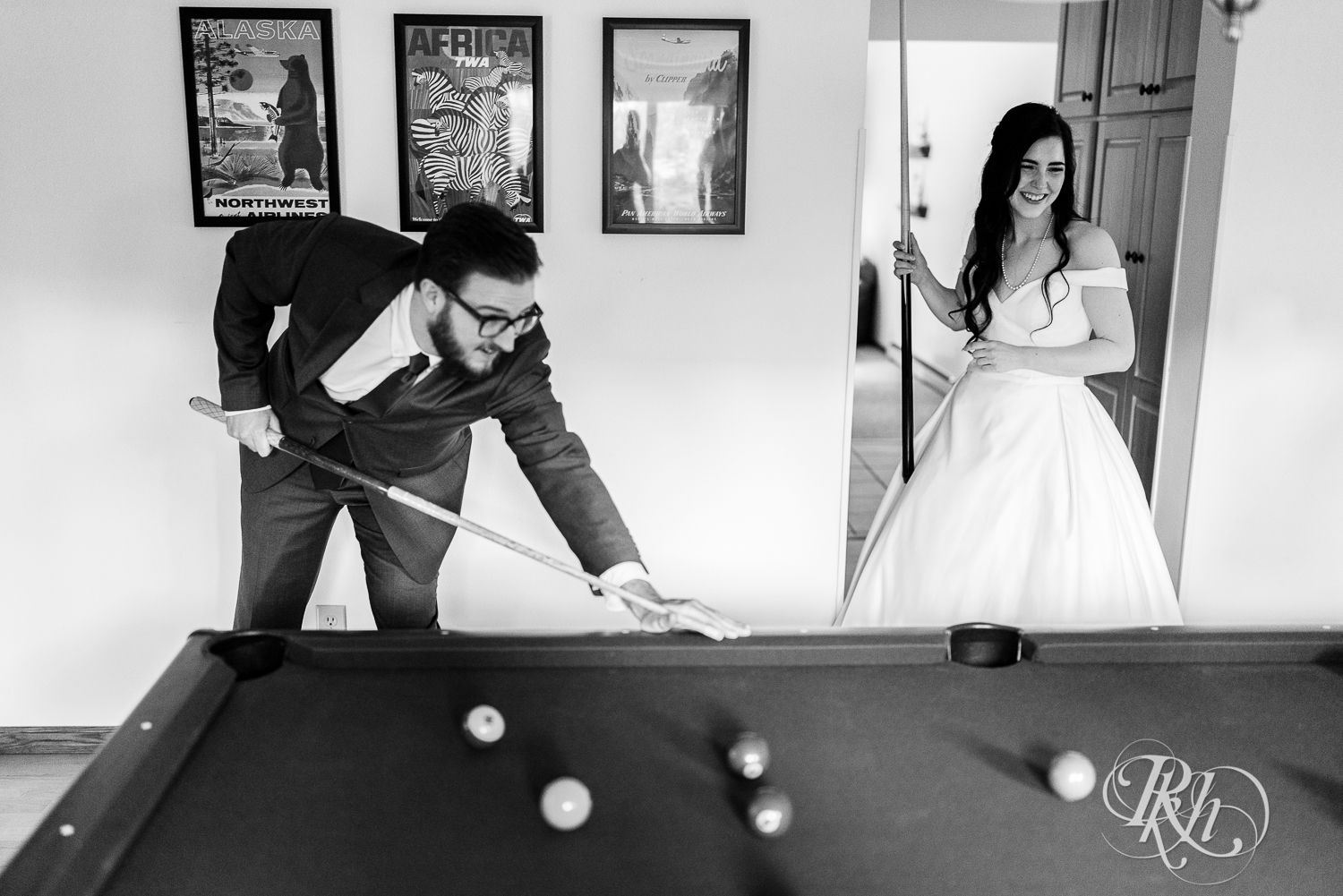 Bride and groom play pool at their house wedding in Sartell, Minnesota.