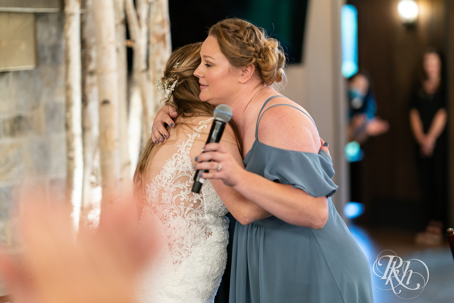 Bride hugging maid of honor during wedding reception at 7 Vines Vineyard in Dellwood, Minnesota.