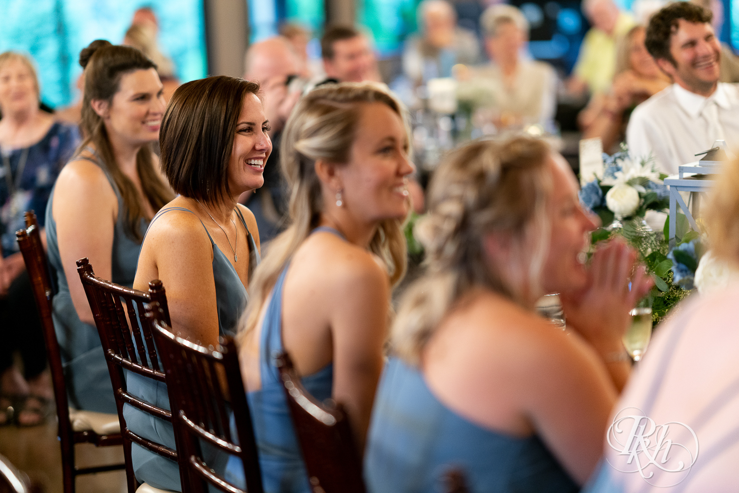 Bridesmaids clapping and laughing during wedding reception at 7 Vines Vineyard in Dellwood, Minnesota.