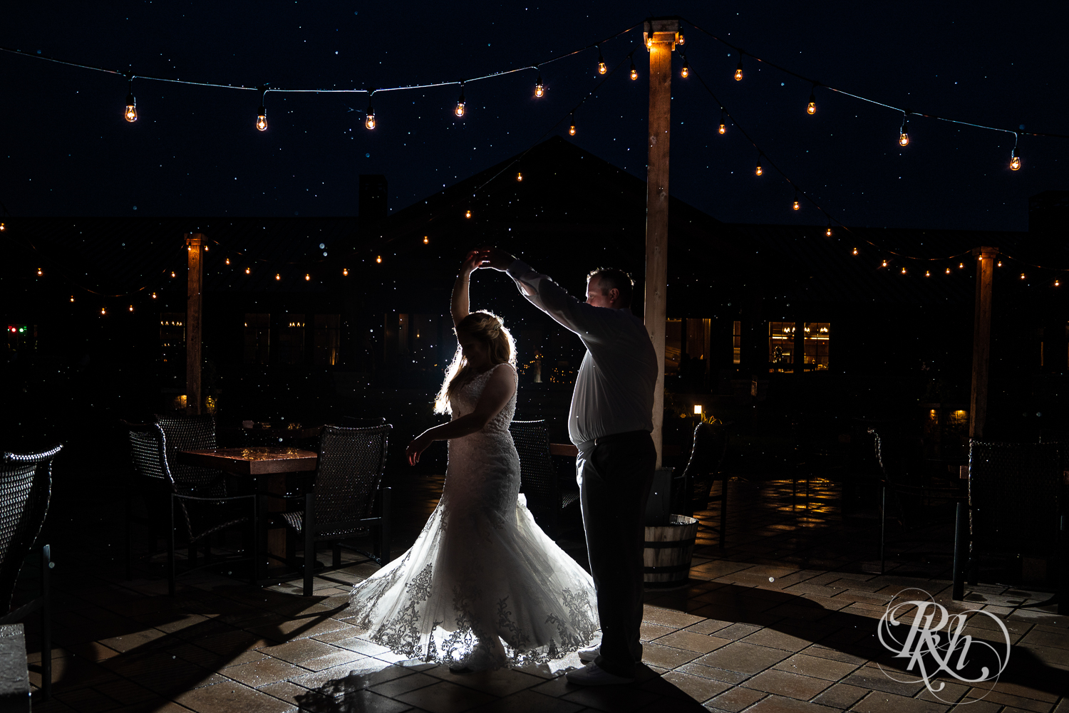 Bride and groom dancing in rainy wedding night at 7 Vines Vineyard in Dellwood, Minnesota.