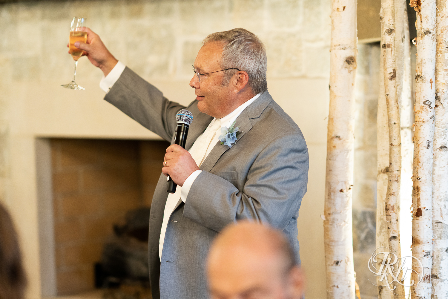 Father toasting with wine glass during wedding reception at 7 Vines Vineyard in Dellwood, Minnesota.