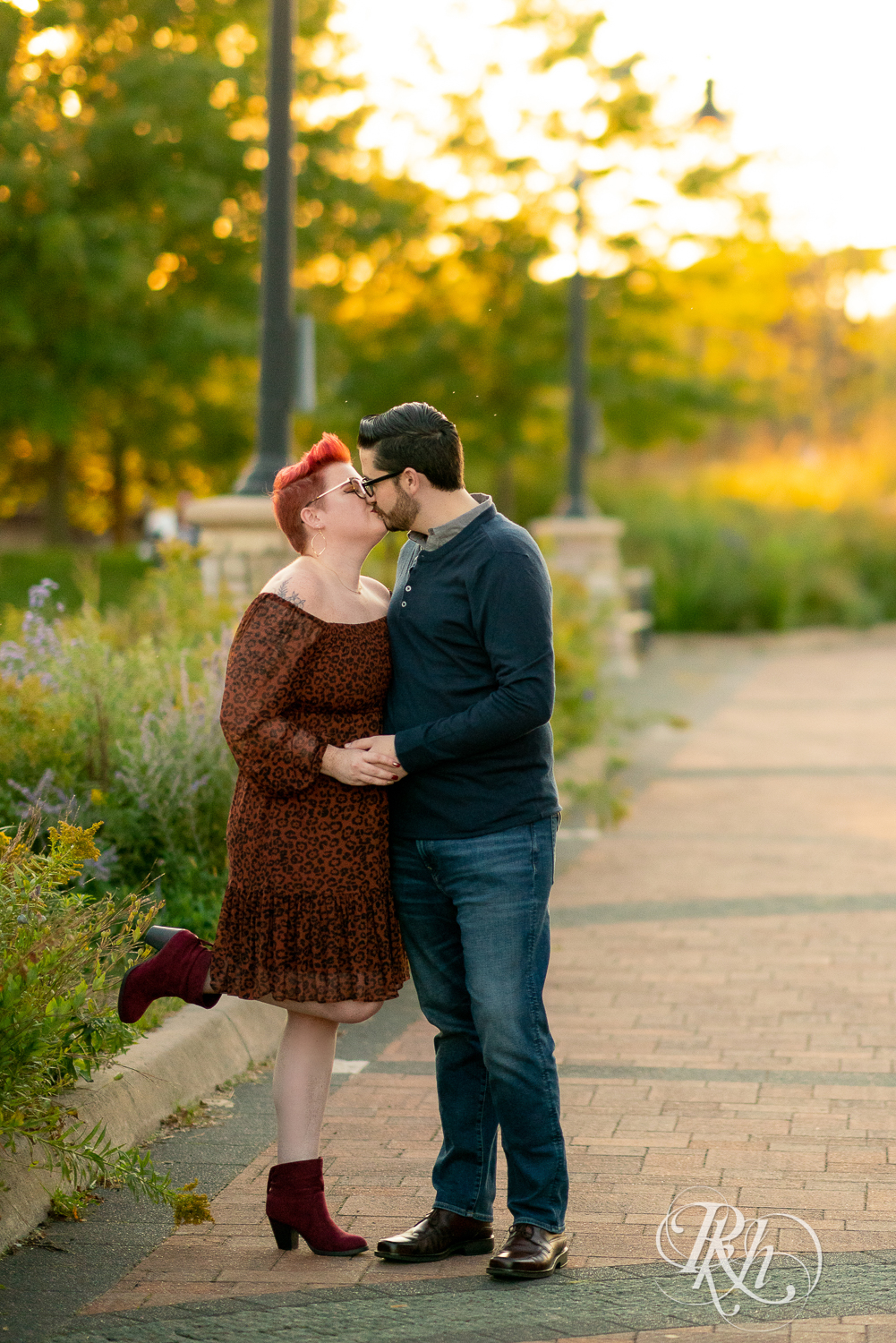 Man and woman with glasses and pixie red hair kissing at sunset in Phoenix Park in Eau Claire, Wisconsin.