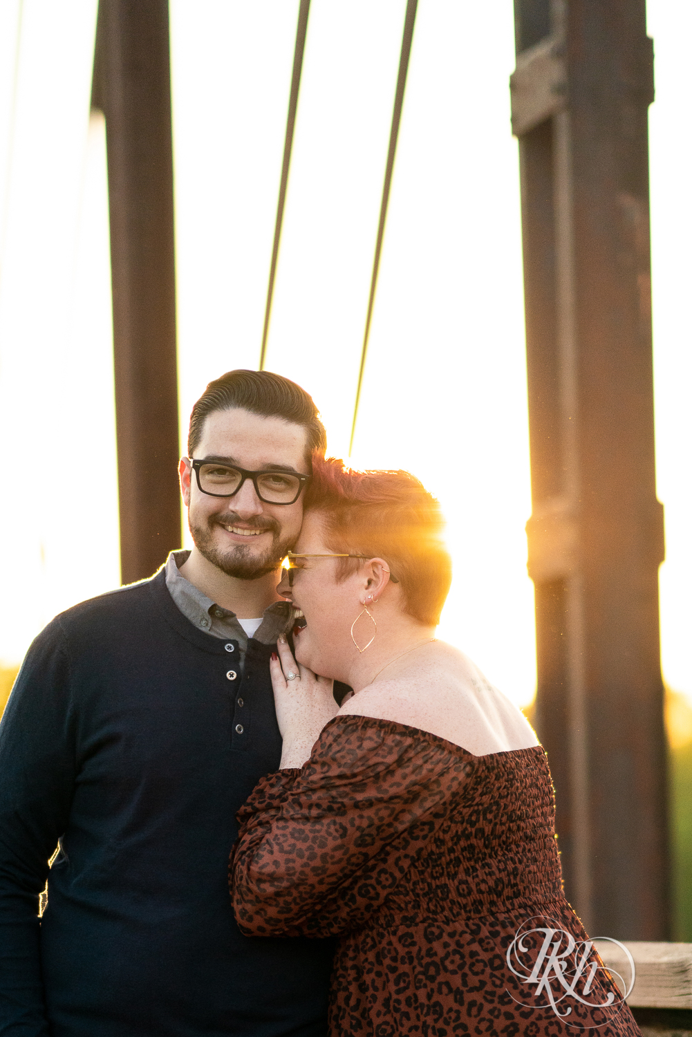 Man and woman with glasses and pixie red hair kissing at sunset in Phoenix Park in Eau Claire, Wisconsin.