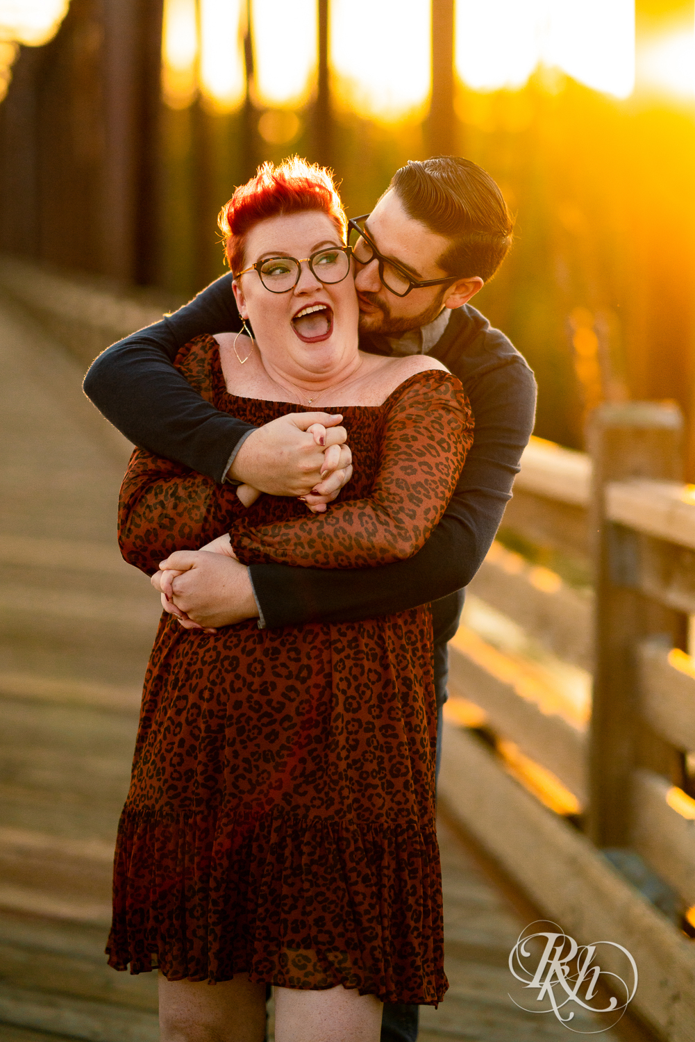Man and woman with glasses and pixie red hair smiling at sunset in Phoenix Park in Eau Claire, Wisconsin.