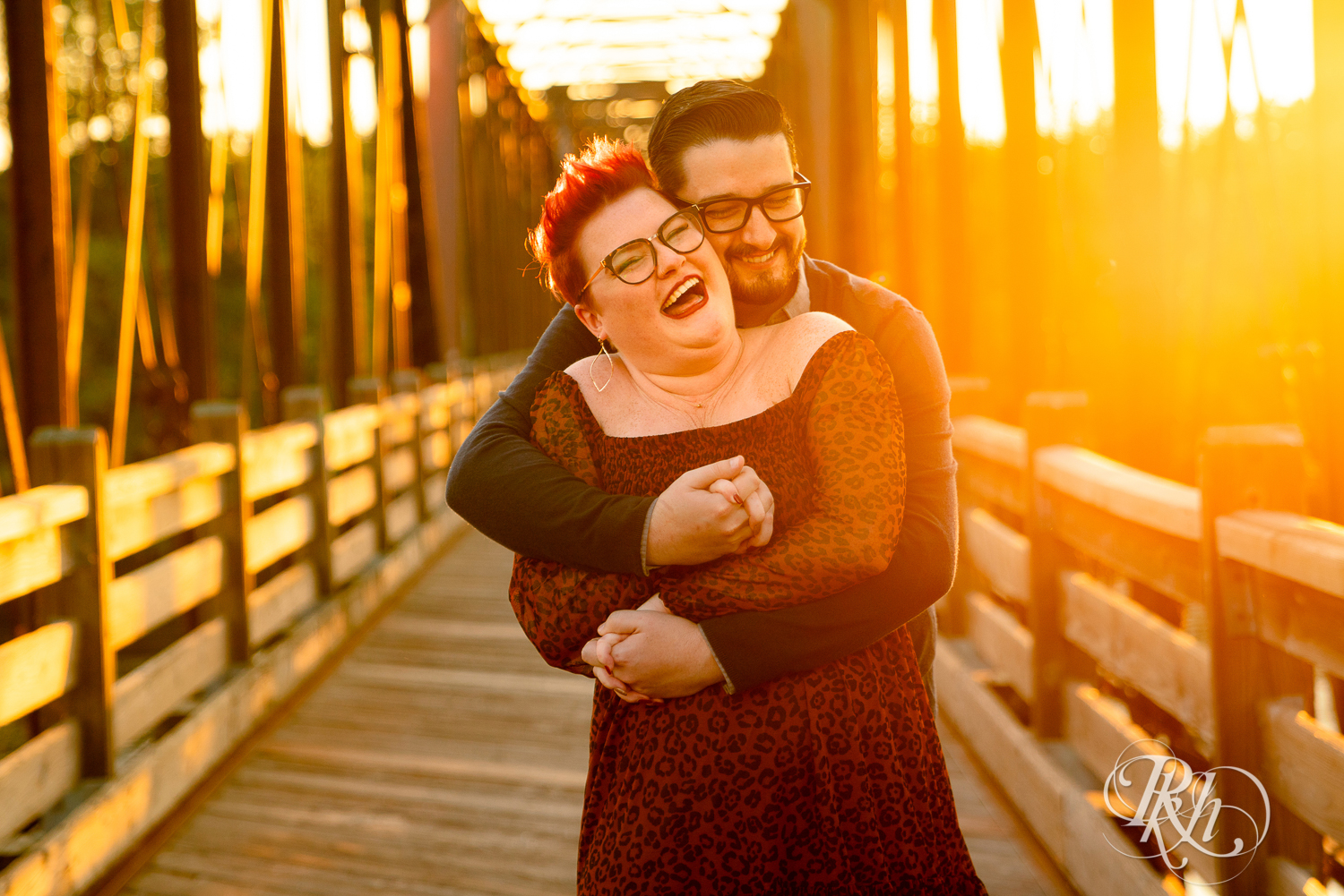 Man and woman with glasses and pixie red hair laughing at sunset in Phoenix Park in Eau Claire, Wisconsin.