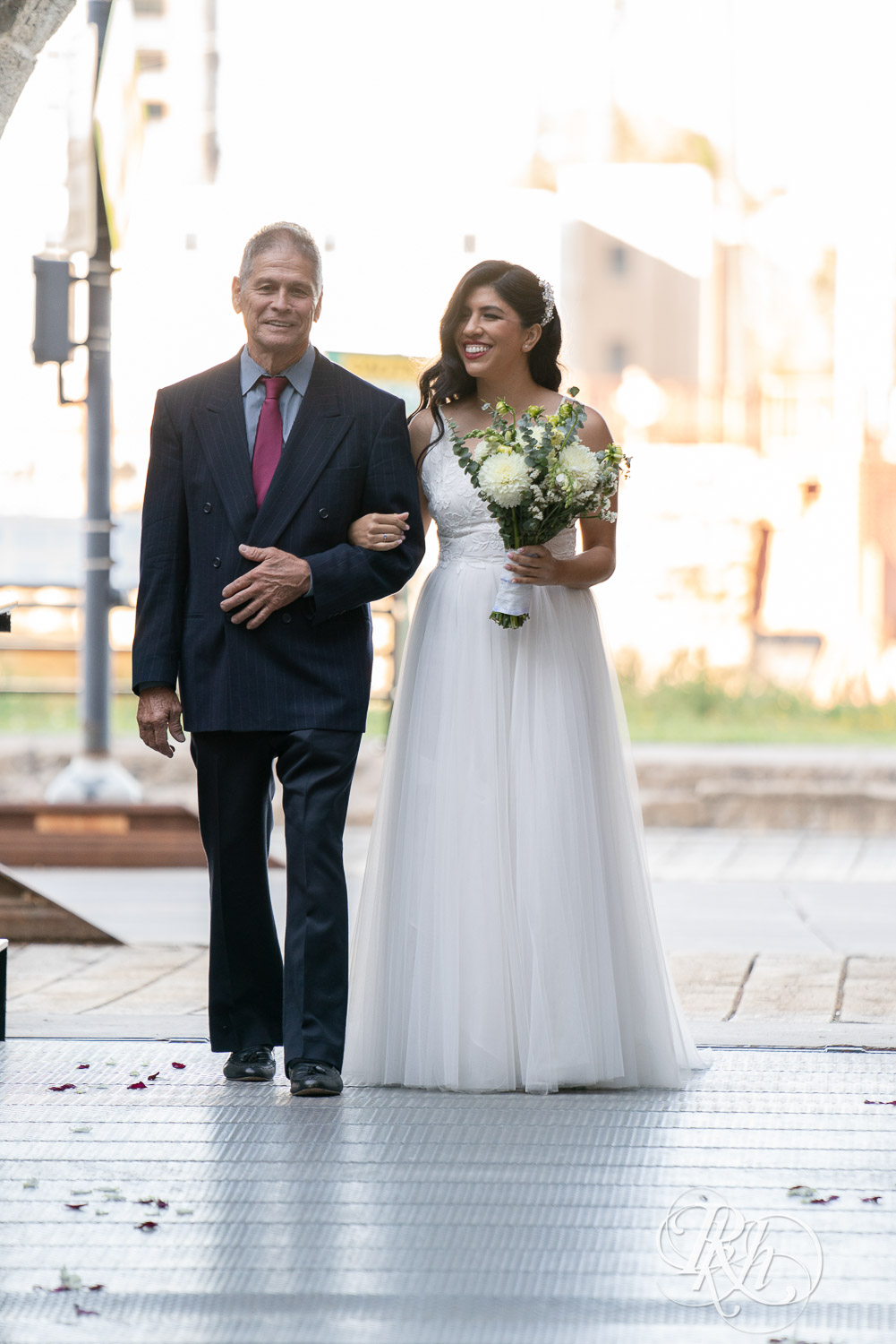 Bride walking down the aisle with her dad at Mill City Museum in Minneapolis, Minnesota