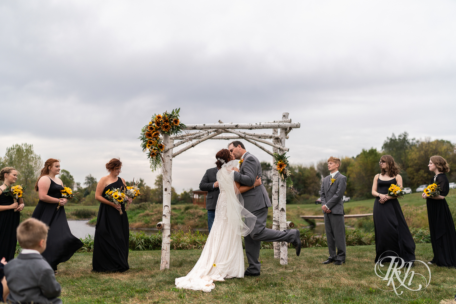 First kiss at outdoor barn wedding ceremony at Barn at Crocker's Creek in Faribault, Minnesota.