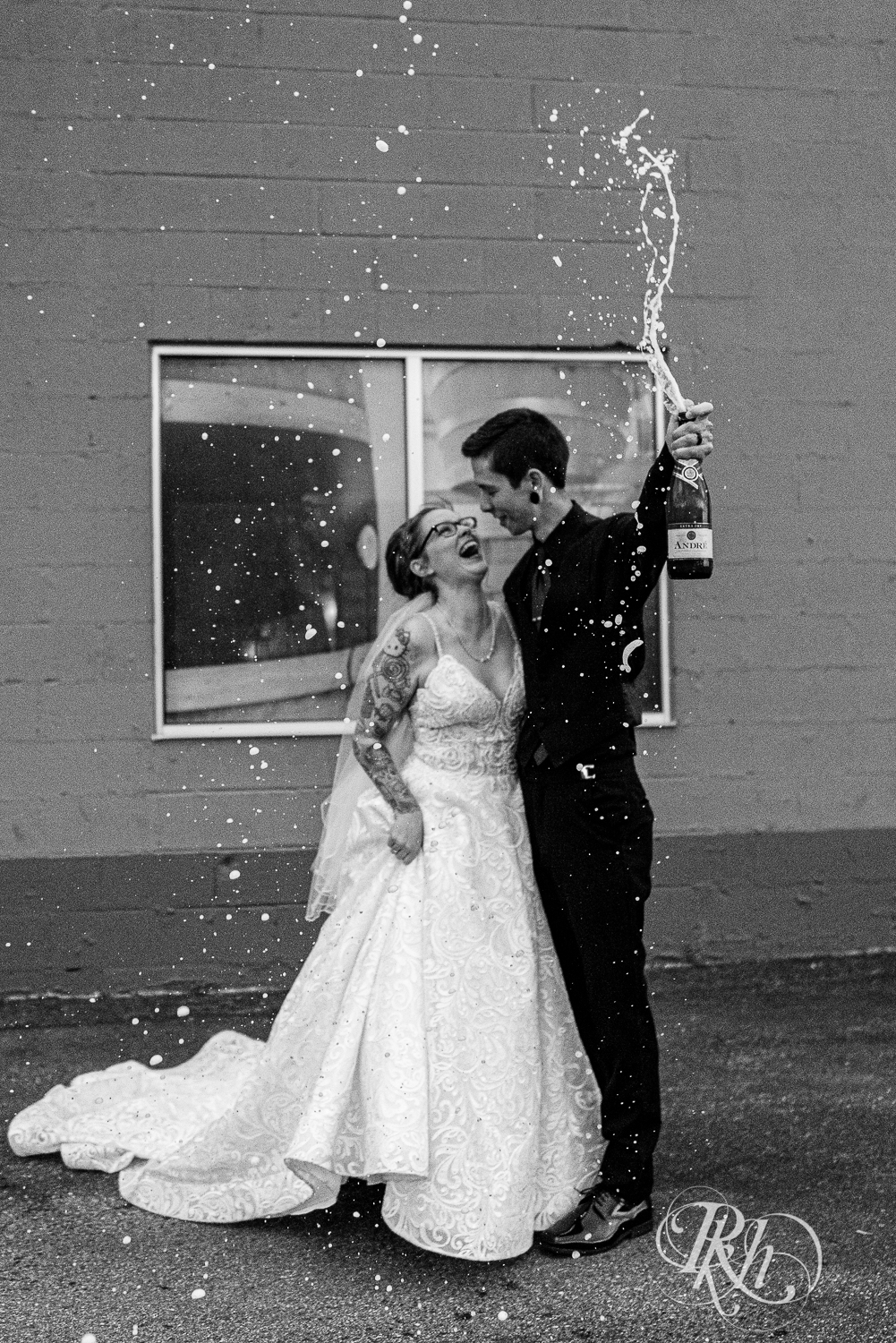 Bride and groom spray champagne at Warehouse Winery in Saint Louis Park, Minnesota.