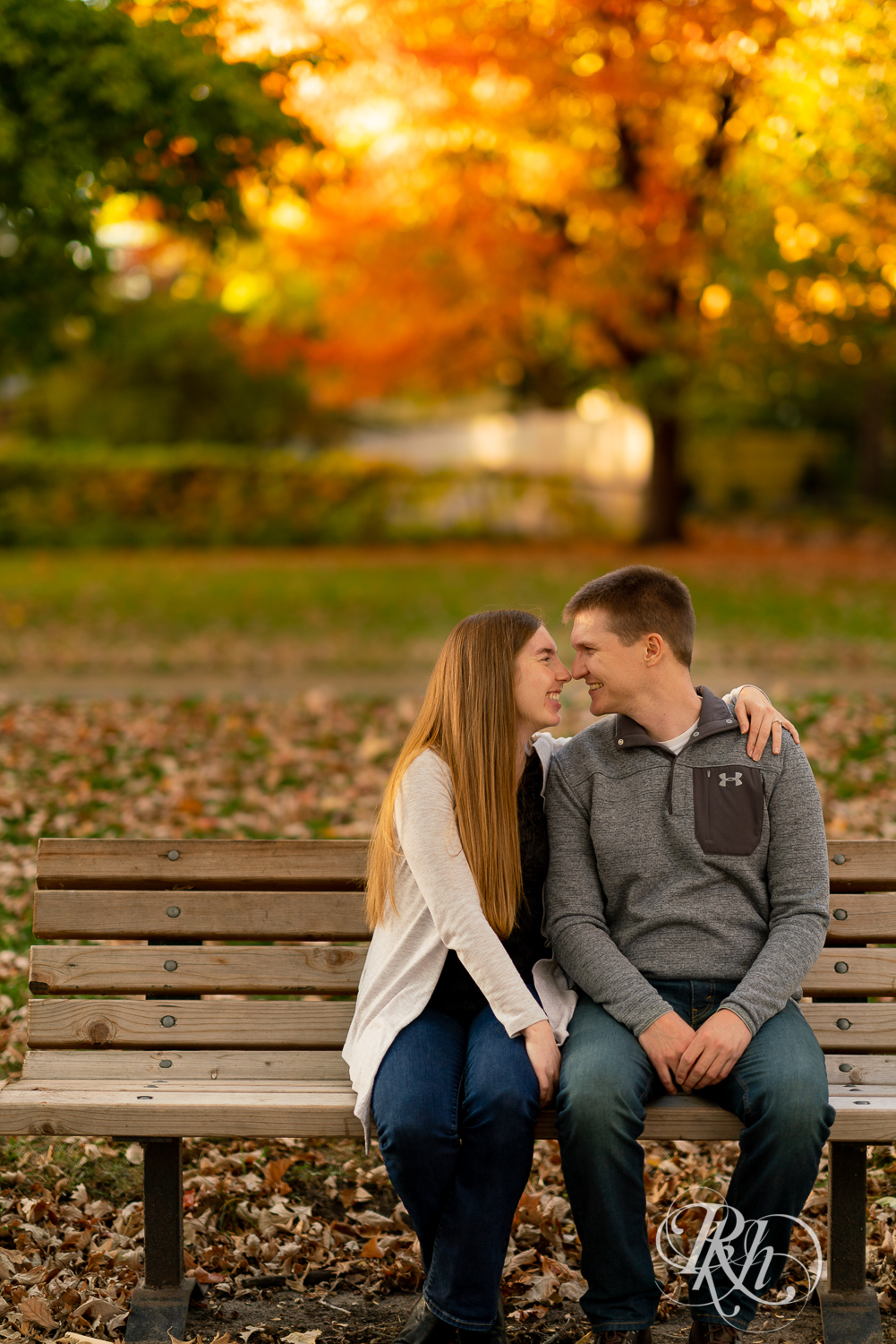 Man and woman kissing on bench during sunset at Matoska Park in White Bear Lake, Minnesota. 