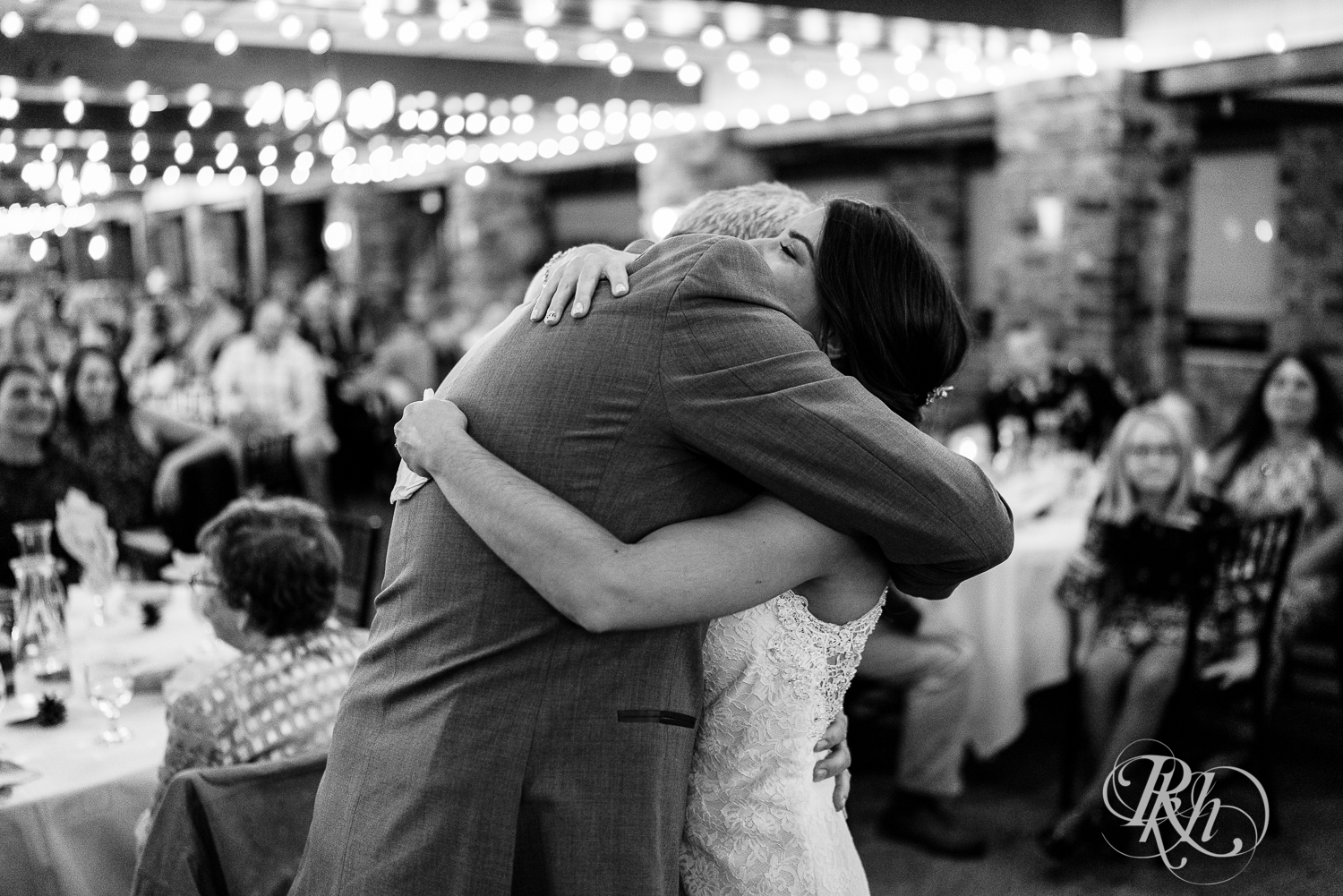Bride hugs dad during reception at The Chart House in Lakeville, Minnesota.
