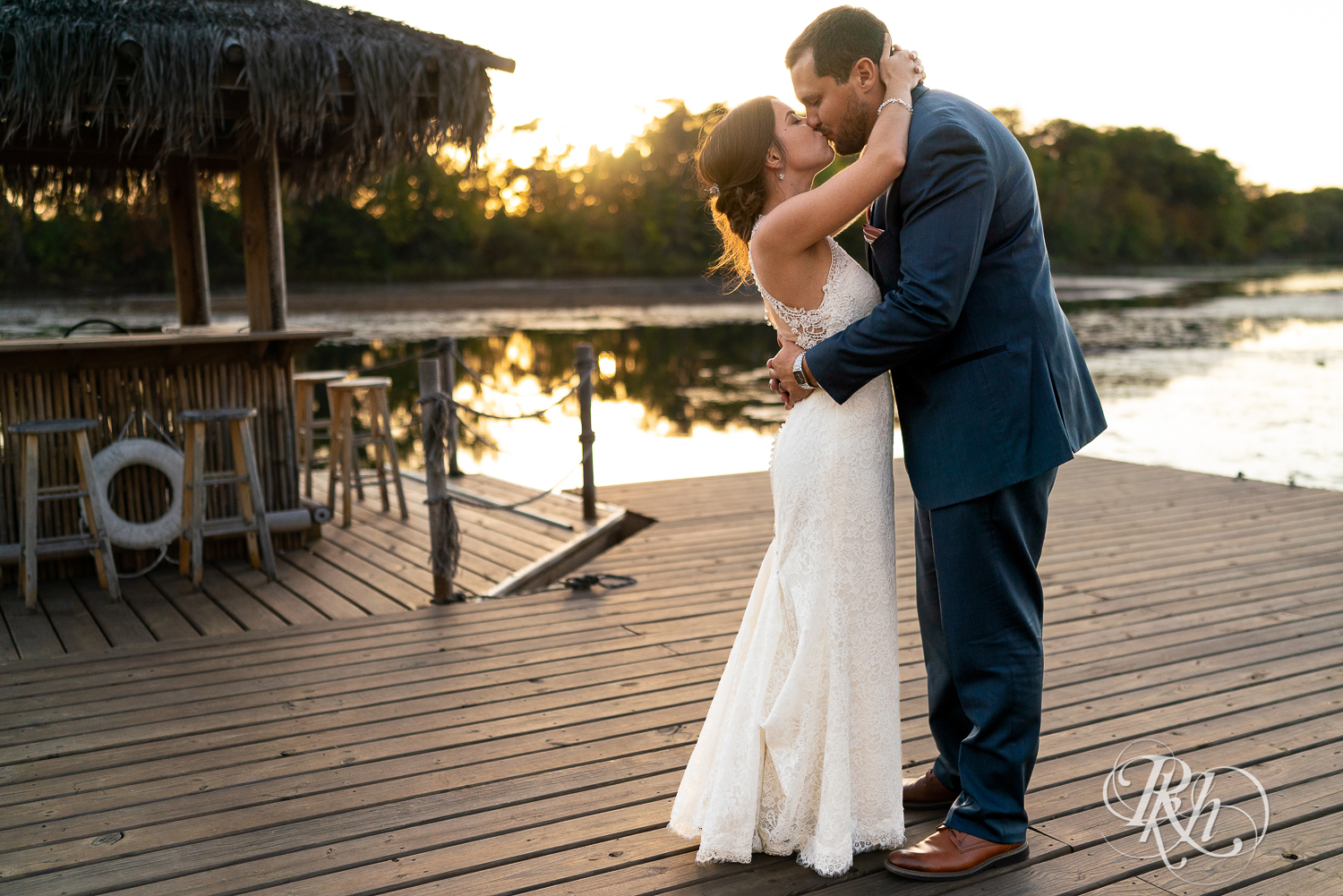 Bride and groom kiss during sunset at The Chart House in Lakeville, Minnesota.