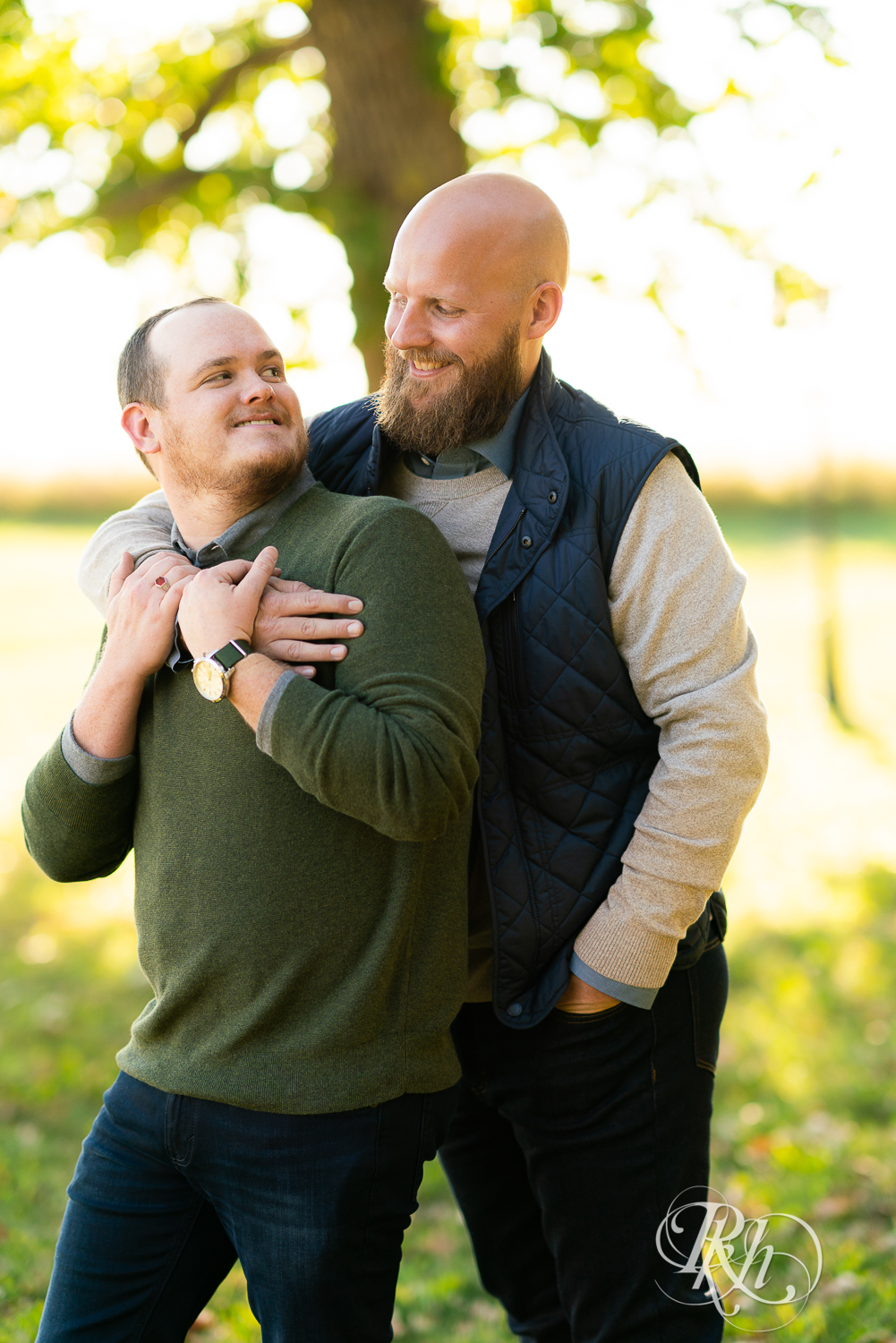 Two gay men holding hands and smiling in Belle Plaine, Minnesota.
