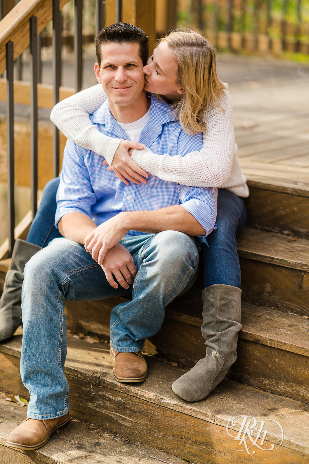 Man and blonde woman smiling at each other during fall engagement photography session in Chaska, Minnesota.